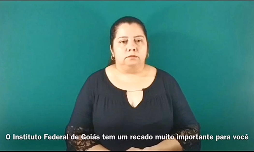 Professora Waléria Vaz em vídeo com informações sobre o coronavírus na Língua Brasileira de Sinais imagem sem descrição.