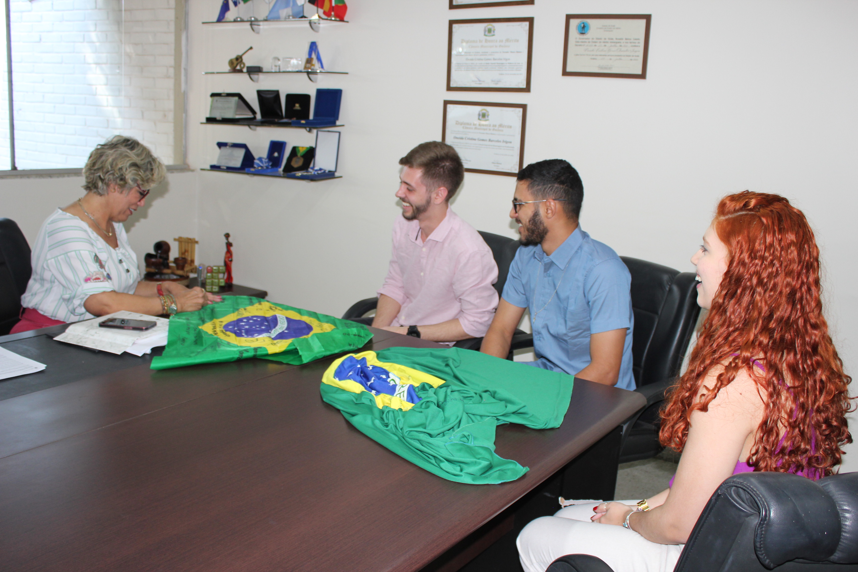 A reitora do IFG assina bandeira do Brasil que será levada pelos estudantes à França